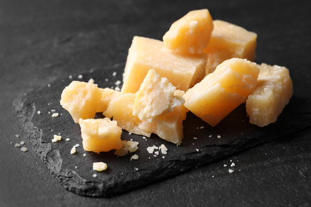 Pieces of delicious parmesan cheese on black table, closeupの写真素材