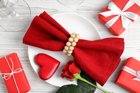 Beautiful place setting with decorative heart on white wooden table, flat lay. Valentine's day romantic dinnerの写真素材