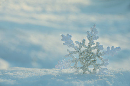 Beautiful decorative snowflake in white snow, outdoors. Space for text