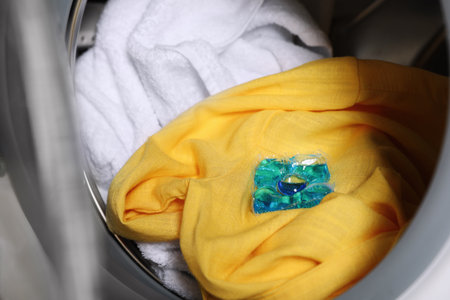 Laundry detergent capsule in washing machine drum, closeup viewの写真素材