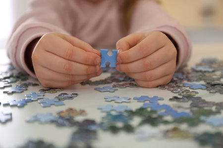 Little child playing with puzzles at table, closeupの写真素材