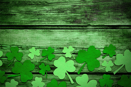 Decorative clover leaves on green wooden background, flat lay with space for text. St. Patrick's Day celebrationの写真素材