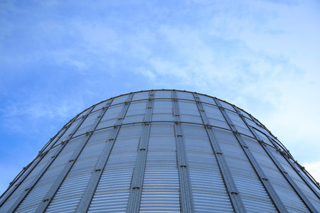 Modern granary for storing cereal grains against blue sky, low angle viewの写真素材
