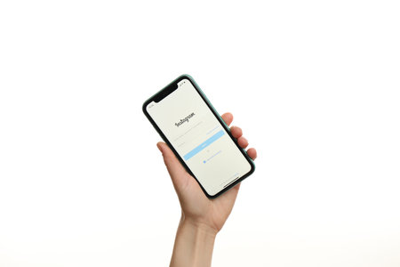 MYKOLAIV, UKRAINE - JULY 9, 2020: Woman holding  iPhone X with Instagram app on white background, closeupのeditorial素材