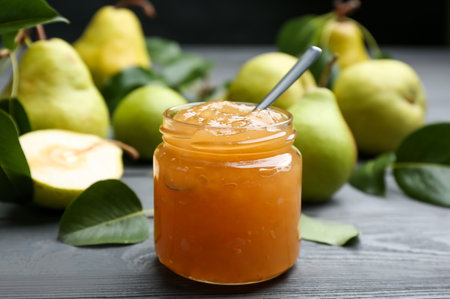 Delicious pear jam and fresh fruits on gray wooden tableの写真素材