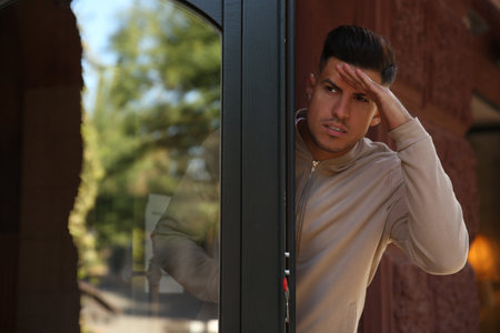 Jealous man spying on ex girlfriend outdoorsの写真素材