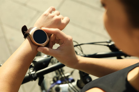 Woman wearing modern smart watch during training outdoors, closeupの写真素材