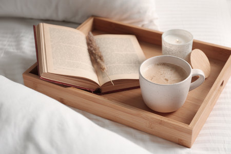 Cup of aromatic coffee, book and candle on white blanket, closeupの写真素材