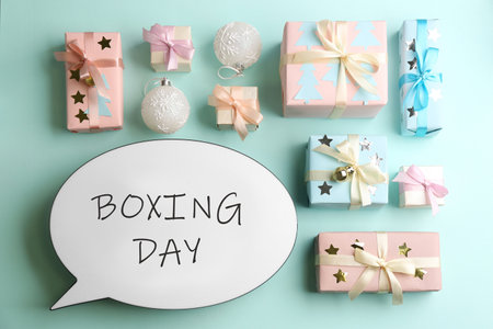 Speech bubble with phrase BOXING DAY and Christmas decorations on light blue background, flat layの写真素材