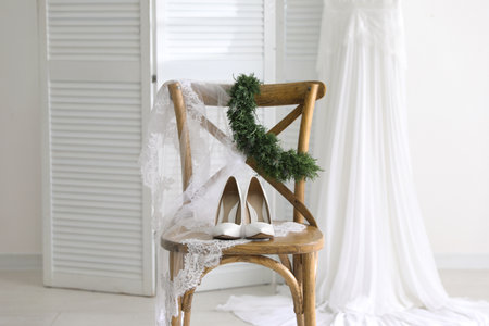 Pair of white high heel shoes, veil and wedding dress indoorsの写真素材