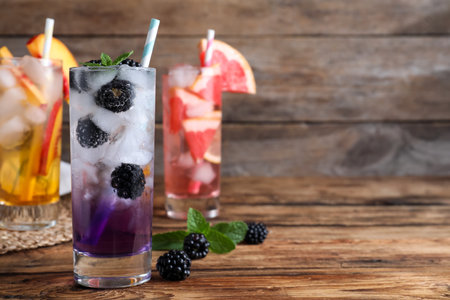 Delicious blackberry lemonade made with soda water and fresh ingredients on wooden table. Space for textの写真素材