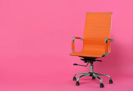 Comfortable office chair on pink background, space for textの写真素材