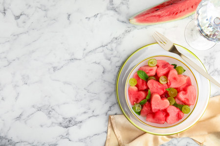 Delicious salad with watermelon on white marble table, flat lay. Space for textの写真素材