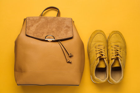 Stylish backpack and shoes on yellow background, flat layの写真素材