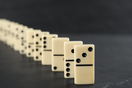 White domino tiles with black pips on dark gray table