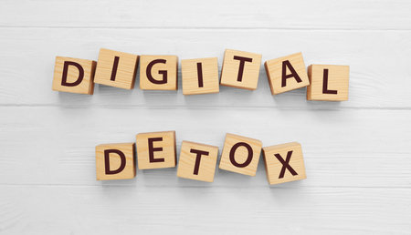 Cubes with phrase DIGITAL DETOX on white wooden table, flat layの写真素材
