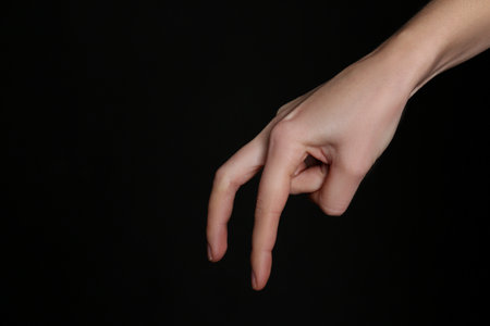 Woman imitating walk with hand on black background, closeup. finger gestureの写真素材