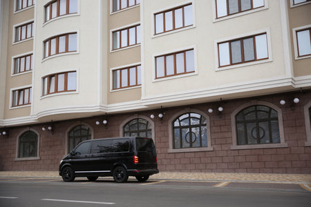 Black delivery van parked on street near building