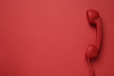 Corded telephone handset on red background, top view. hotline conceptの写真素材