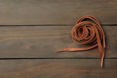 Brown shoelaces on wooden background, top view. Space for textの写真素材
