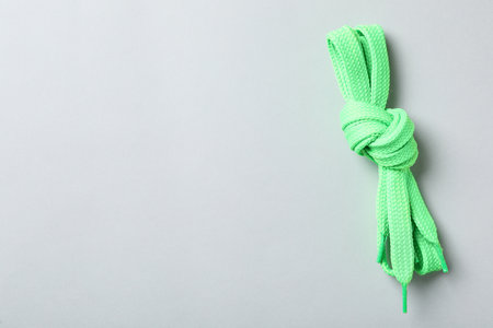 Green shoelaces on light background, top view. Space for textの写真素材
