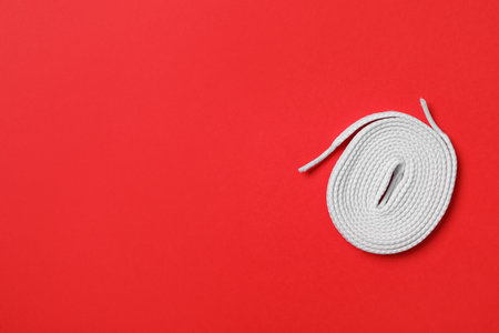 White shoelace on red background, top view. Space for textの写真素材