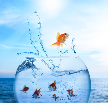 Goldfish jumping out of water and beautiful seascape on backgroundの写真素材