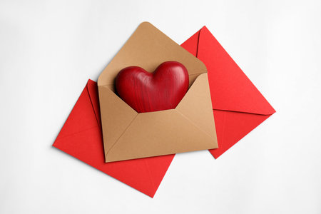 Decorative heart in envelope on white background, flat lay. love lettersの写真素材