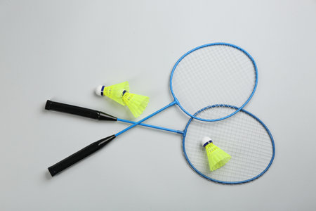 Rackets and shuttlecocks on light gray background, flat lay. badminton equipment