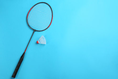 Racket and shuttlecock on light blue background, flat lay with space for text. badminton equipmentの写真素材