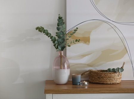 Vase with fresh eucalyptus branches on cabinet in room. interior designの写真素材