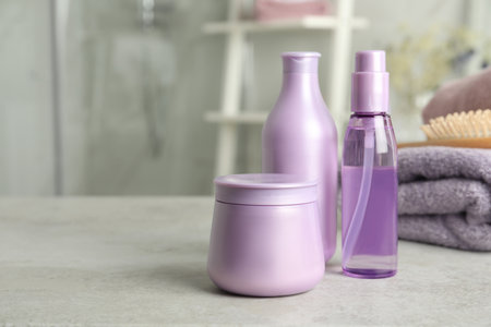 Set of hair care cosmetic products on light gray stone table in bathroom. Space for textの写真素材