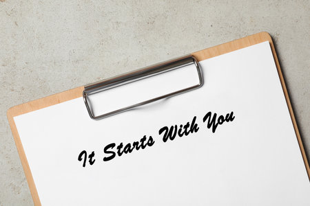 Clipboard with phrase It Starts With You on gray table, top viewの写真素材