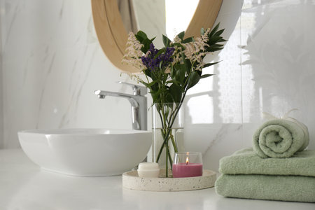 Beautiful flowers, towels and candles on countertop in the bathroom. interior decorの写真素材