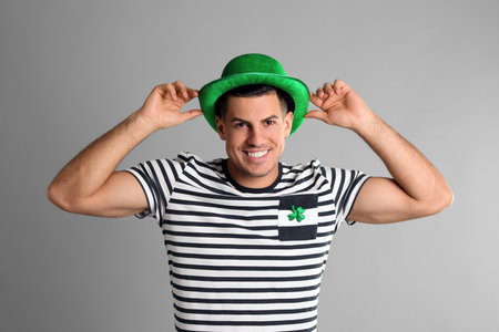 Happy man in St Patrick's Day outfit on light gray backgroundの写真素材