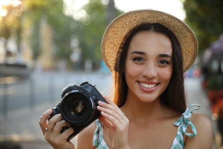 Young photographer with professional camera on city streetの写真素材