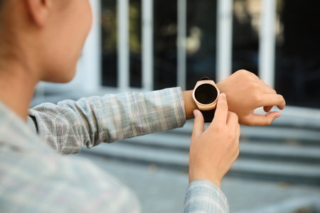 Young woman with smart watch outdoors, closeup