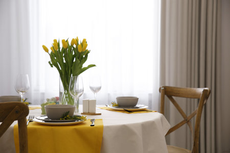 Beautiful Easter table setting with floral decor indoorsの写真素材