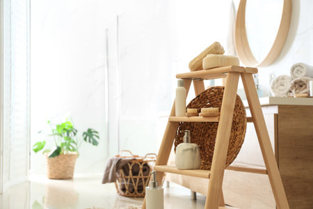 Dispensers and different toiletries on decorative ladder in bathroom. Idea for interior designの写真素材