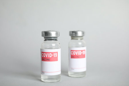 Vials with coronavirus vaccine on light backgroundの写真素材