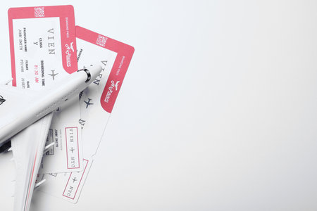 Toy airplane and tickets on white background, flat lay with space for text. travel agency conceptの写真素材