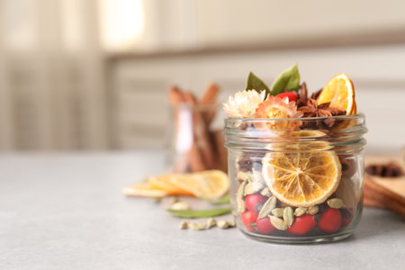 Aromatic potpourri in glass jar on light table. Space for textの写真素材