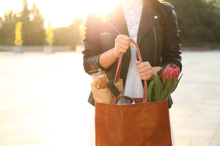 Woman with leather shopper bag on city street, closeupの写真素材