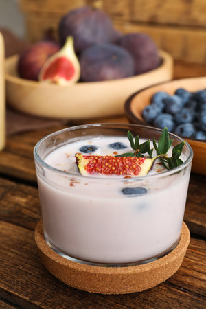 Delicious fig smoothie in glass on wooden tableの写真素材