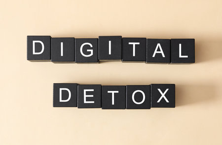 Black cubes with words DIGITAL DETOX on beige background, flat layの写真素材