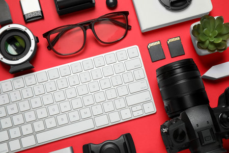 Flat lay composition with camera and video production equipment on red backgroundの写真素材