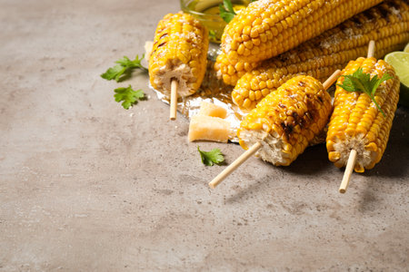 Delicious grilled corn cobs on gray table. Space for textの写真素材