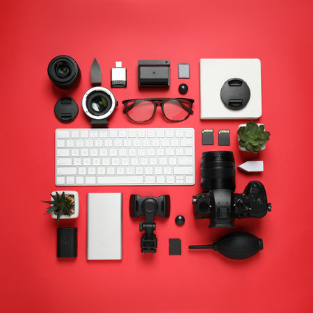 Flat lay composition with camera and video production equipment on red backgroundの写真素材