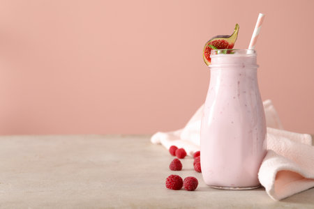 Delicious fig smoothie in bottle on light table, space for textの写真素材