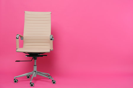Comfortable office chair on pink background, space for textの写真素材